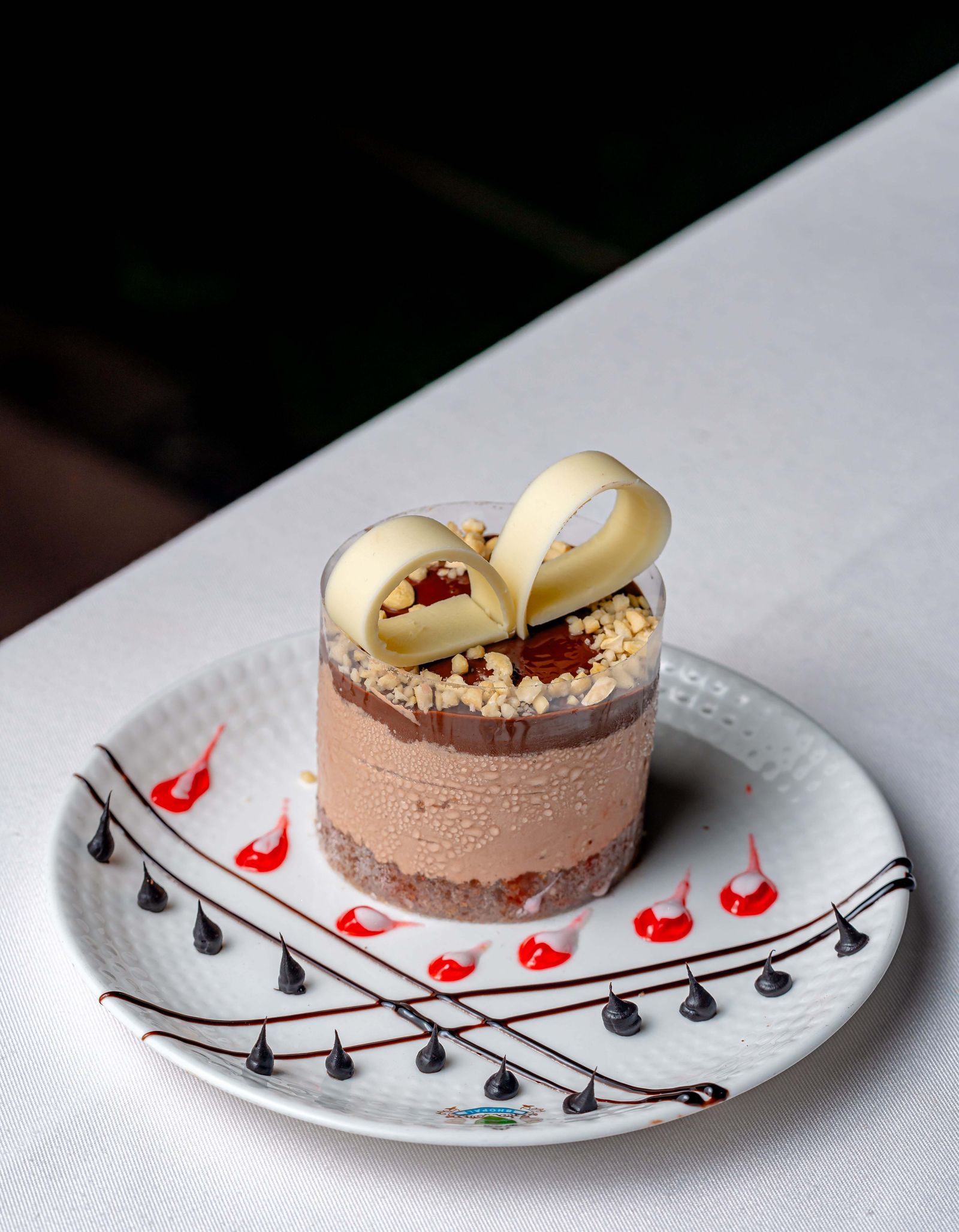 A chocolate mousse with a white chocolate ribbon